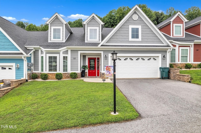 view of front of house featuring a garage, aphalt driveway, a front lawn, and a shingled roof