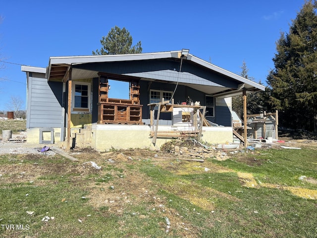 rear view of property with a yard and a porch