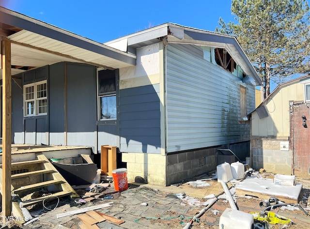 view of side of property with entry steps and crawl space