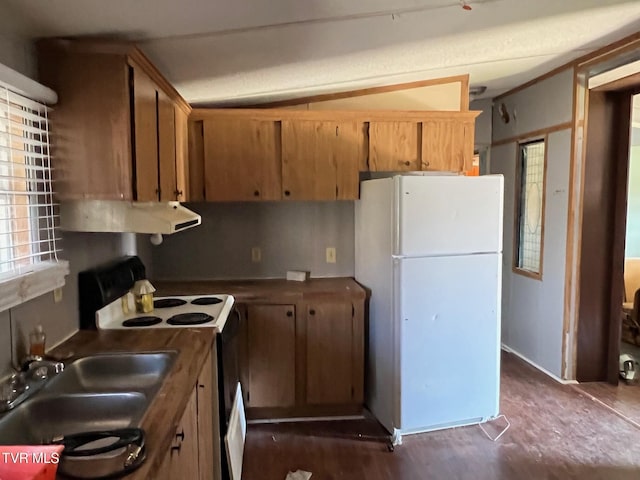 kitchen with white appliances, brown cabinets, a sink, and under cabinet range hood