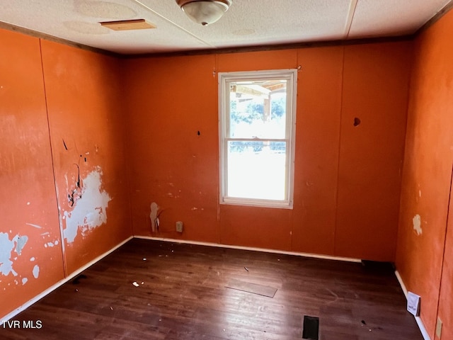 unfurnished room featuring dark wood-style floors and a textured ceiling