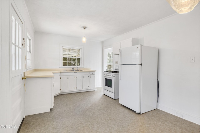 kitchen featuring light countertops, hanging light fixtures, white cabinets, a sink, and white appliances