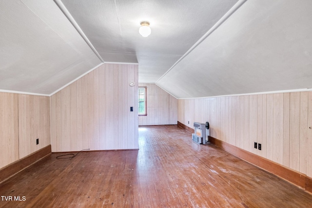 bonus room with vaulted ceiling, wood walls, dark wood finished floors, and heating unit