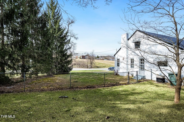 view of yard with central AC and fence