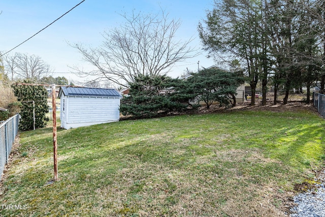 view of yard with a storage shed, a fenced backyard, and an outbuilding