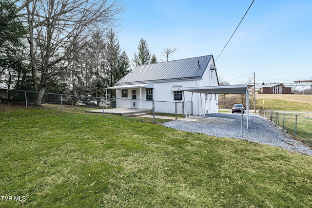 back of property featuring metal roof, a lawn, fence private yard, and stucco siding