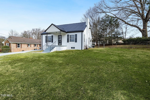 bungalow-style home with metal roof, a front lawn, a chimney, and fence