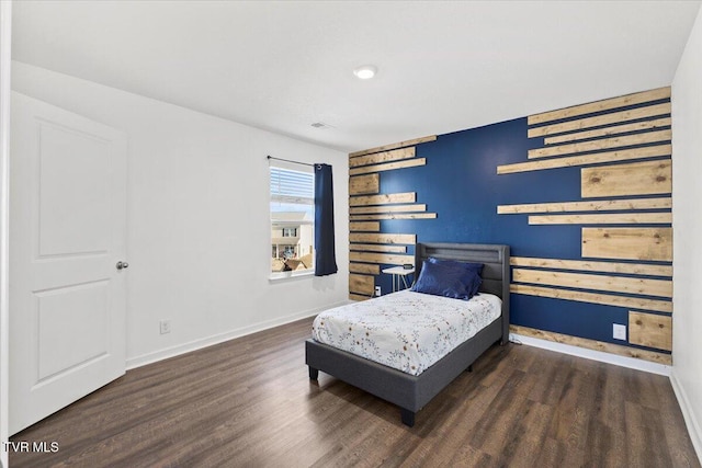 bedroom with dark wood-style floors, visible vents, and baseboards