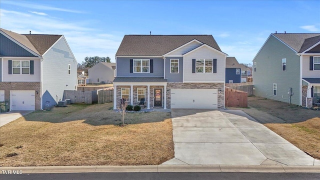 traditional-style home featuring a garage, driveway, fence, cooling unit, and a front lawn