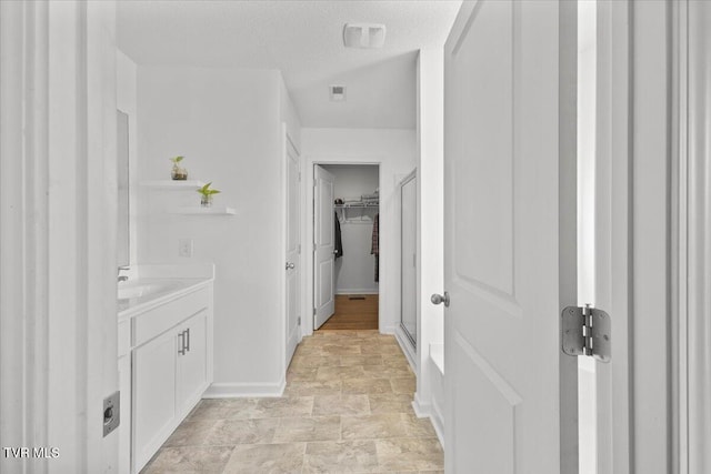 full bathroom with visible vents, a stall shower, vanity, a textured ceiling, and baseboards