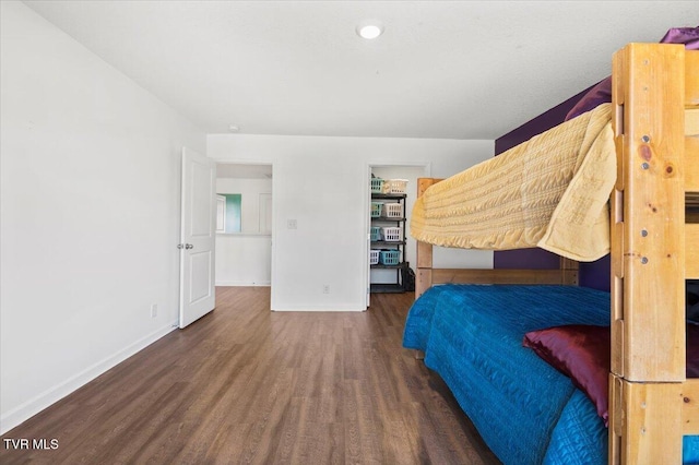 unfurnished bedroom with dark wood-style flooring and baseboards