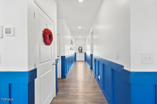 corridor featuring dark wood-style floors, recessed lighting, and wainscoting