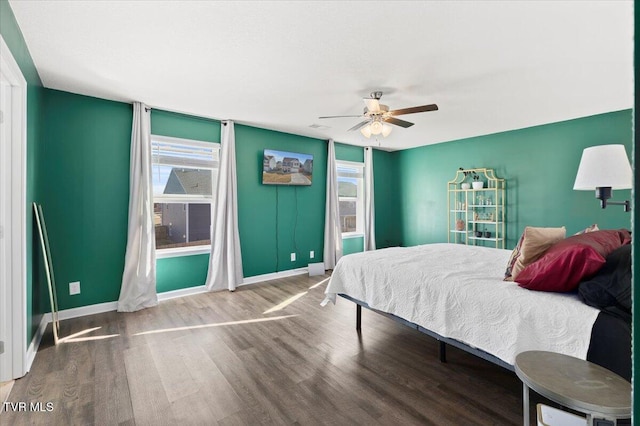 bedroom featuring ceiling fan, baseboards, and wood finished floors