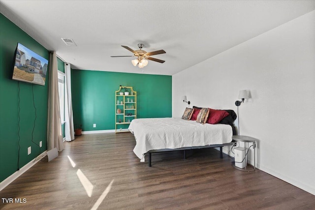 bedroom featuring a ceiling fan, visible vents, dark wood finished floors, and baseboards