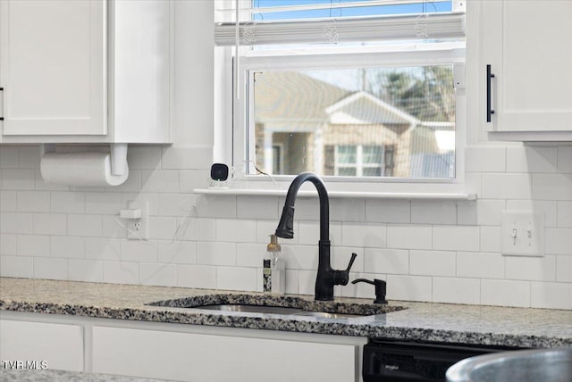 kitchen with a sink, a wealth of natural light, and white cabinets