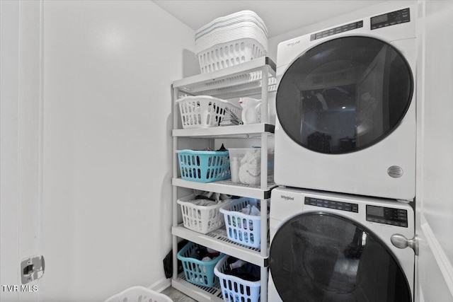 laundry room featuring stacked washer / drying machine and laundry area