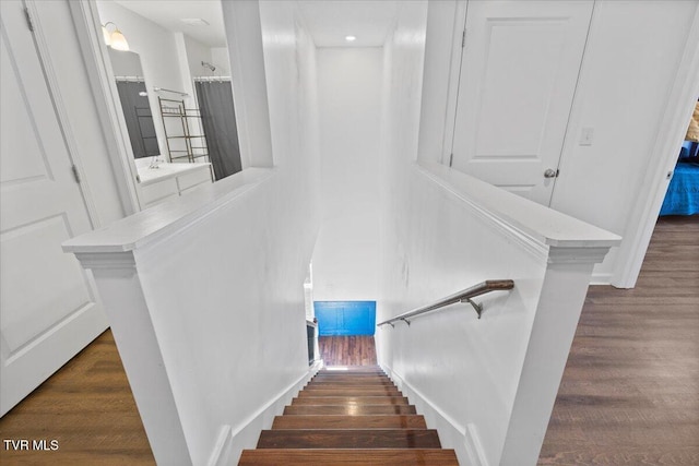 staircase featuring baseboards and wood finished floors