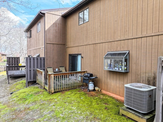 back of house with cooling unit, a yard, and a deck