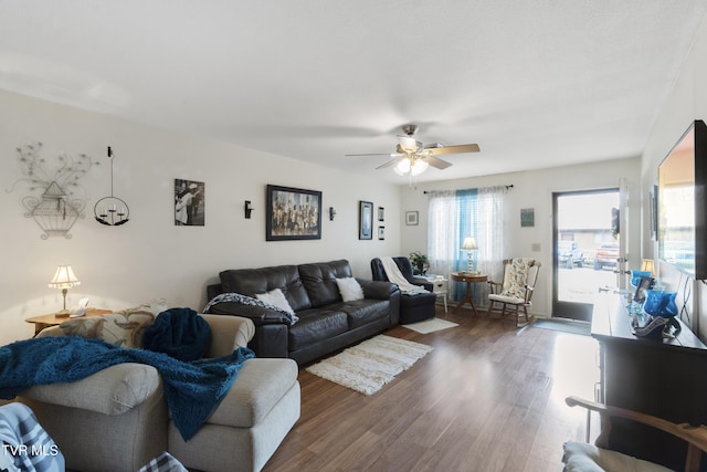 living area featuring a ceiling fan and dark wood finished floors