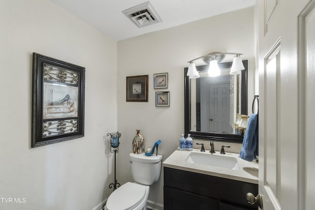 bathroom featuring toilet, vanity, and visible vents