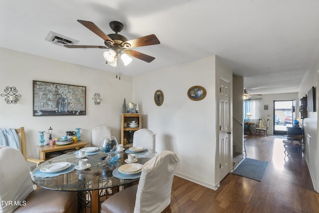 dining space featuring a ceiling fan, visible vents, baseboards, and wood finished floors