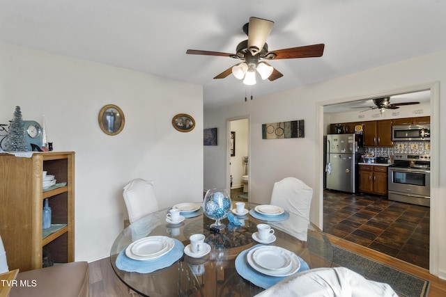 dining area featuring a ceiling fan, dark wood-style flooring, and baseboards