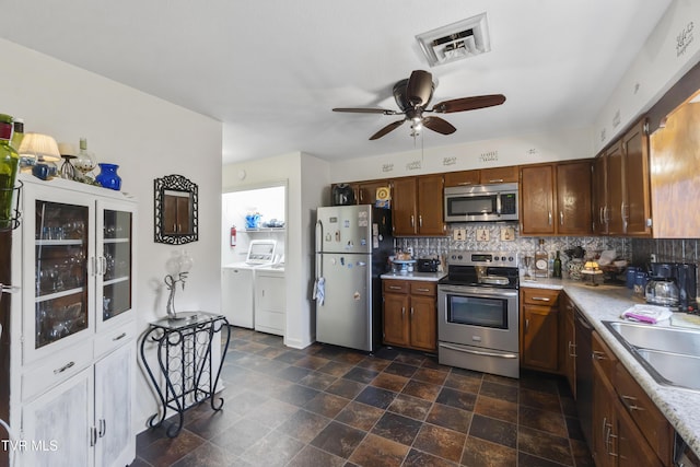 kitchen featuring visible vents, light countertops, appliances with stainless steel finishes, tasteful backsplash, and washer and clothes dryer