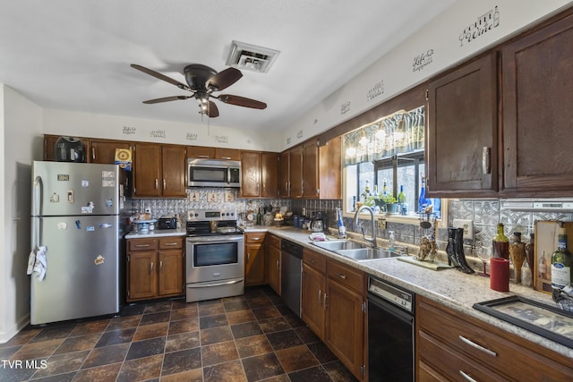 kitchen with stainless steel appliances, visible vents, a sink, and backsplash