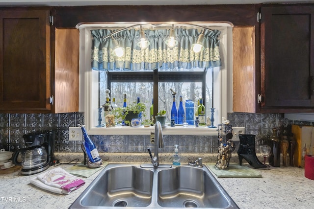 kitchen with decorative backsplash, light countertops, and a sink