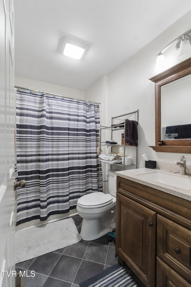 bathroom featuring tile patterned flooring, curtained shower, vanity, and toilet