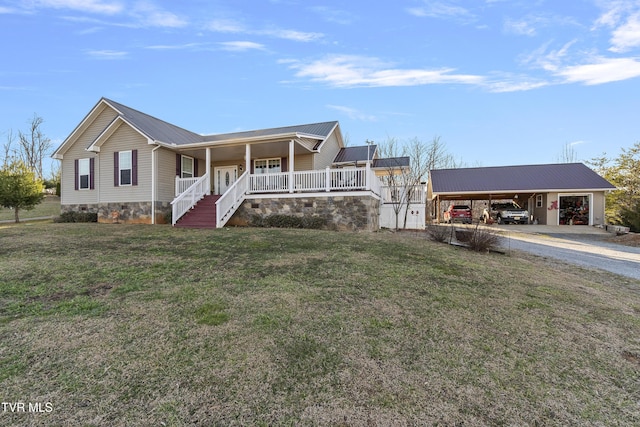 view of front facade with metal roof, covered porch, driveway, a carport, and a front lawn