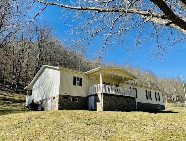 view of front of home with a front yard, crawl space, central AC, and an attached garage