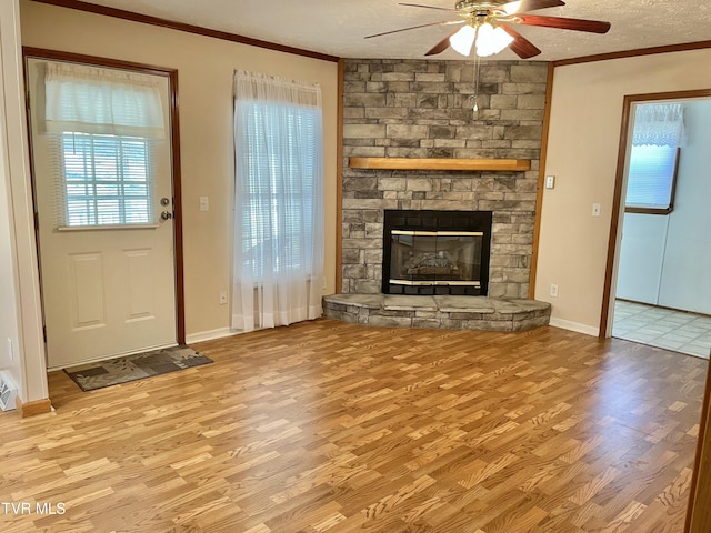 unfurnished living room featuring a fireplace, crown molding, a textured ceiling, and wood finished floors