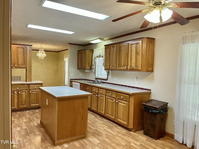 kitchen with light wood-style floors, a center island, brown cabinets, and white dishwasher