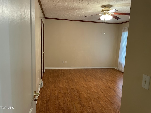 unfurnished room featuring ceiling fan, crown molding, a textured ceiling, and wood finished floors