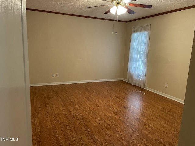 empty room with a textured ceiling, wood finished floors, and crown molding