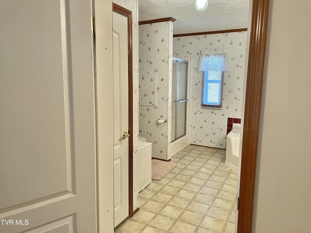 bathroom featuring wallpapered walls, a shower stall, a textured ceiling, and tile patterned floors