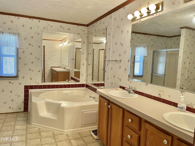 full bathroom featuring a textured ceiling, a stall shower, a sink, and wallpapered walls