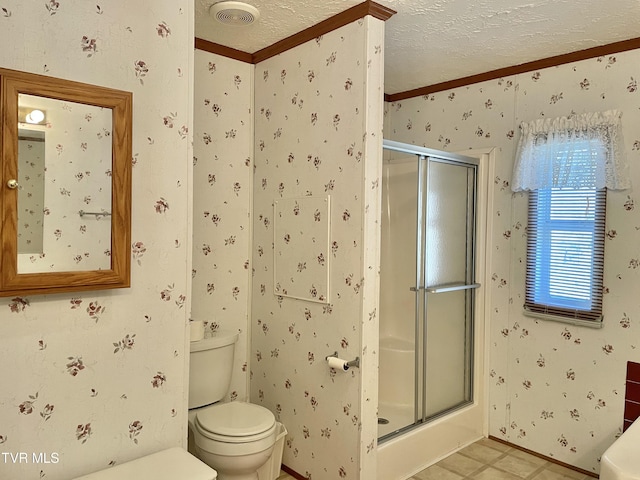 full bath with visible vents, toilet, a shower stall, a textured ceiling, and wallpapered walls