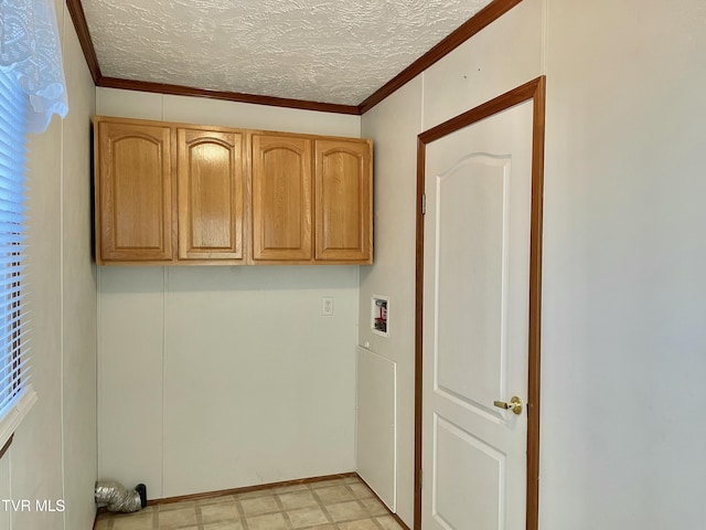 laundry area with a textured ceiling, washer hookup, cabinet space, light floors, and crown molding