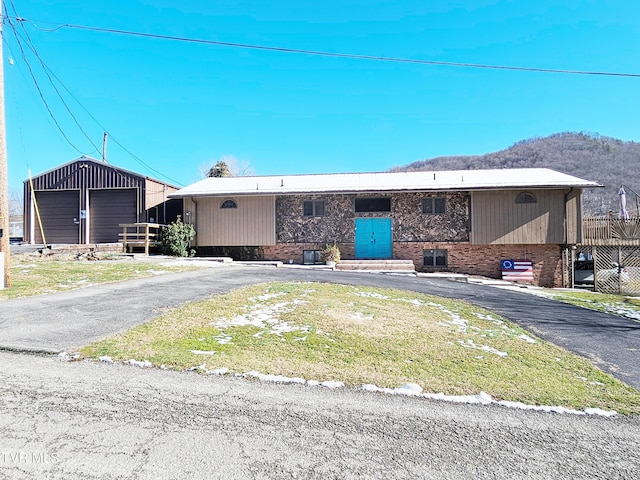 view of front of home featuring brick siding, a mountain view, and an outdoor structure