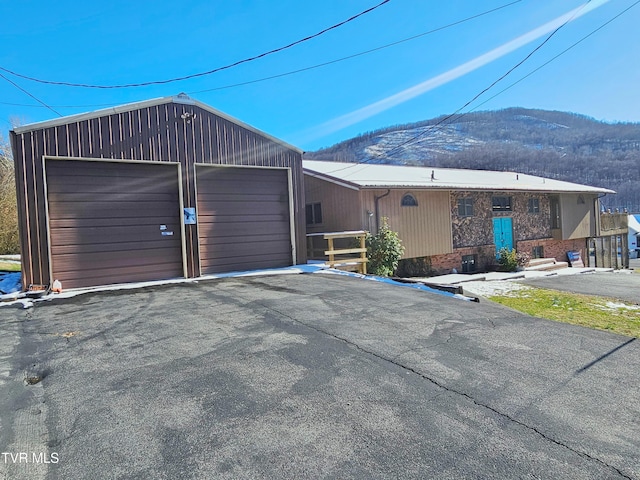 view of front of home with a garage, a mountain view, and driveway