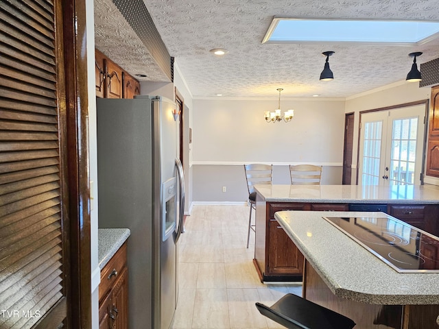 kitchen with a kitchen bar, a kitchen island, stainless steel fridge with ice dispenser, and black electric cooktop