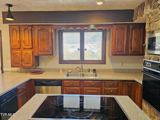 kitchen with light countertops, a sink, hanging light fixtures, and black appliances