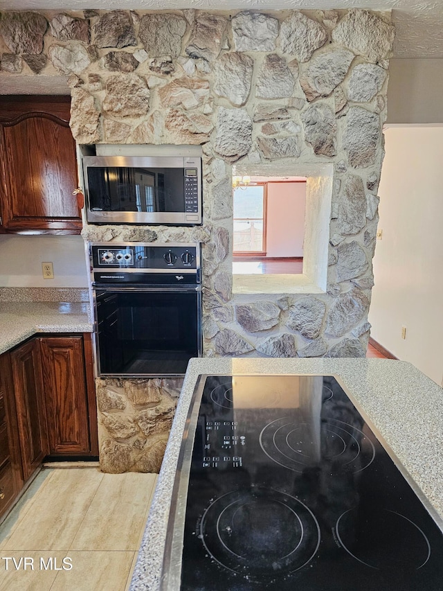 kitchen featuring black appliances, light countertops, and dark brown cabinetry