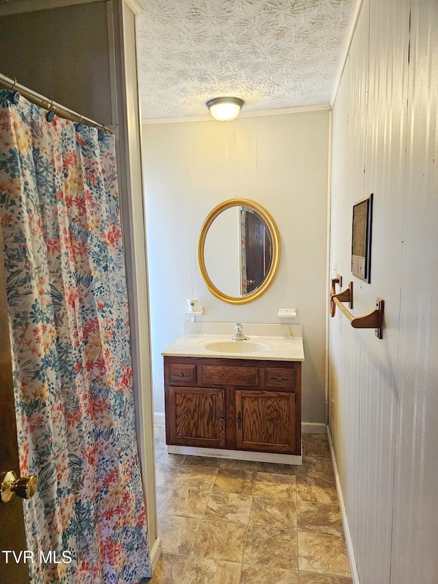 full bathroom with a textured ceiling, ornamental molding, vanity, and a shower with curtain