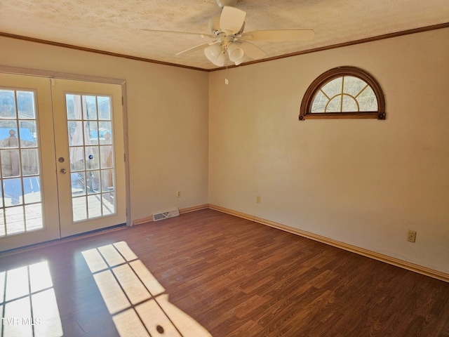 unfurnished room with a textured ceiling, french doors, wood finished floors, and crown molding