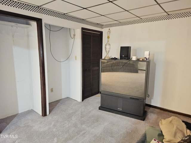 bedroom with light colored carpet and a drop ceiling