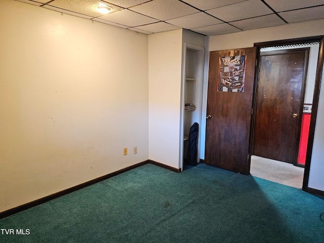 unfurnished bedroom featuring a paneled ceiling, baseboards, and dark colored carpet