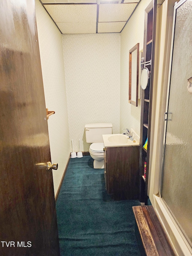 bathroom featuring a drop ceiling, vanity, toilet, and wallpapered walls